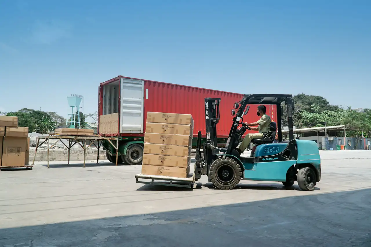 A forklift loading goods into a shipping container
