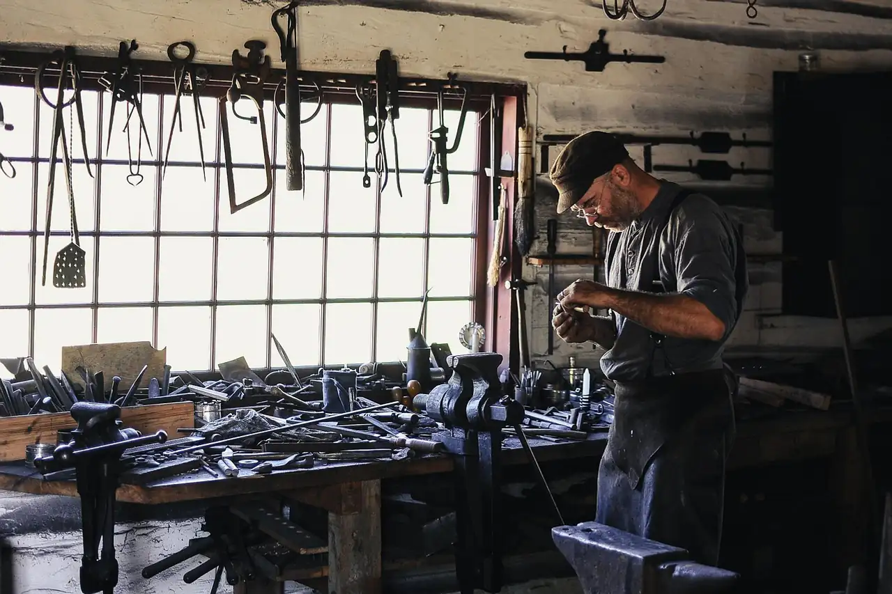 A craftsman working at a bench in a metal workshop