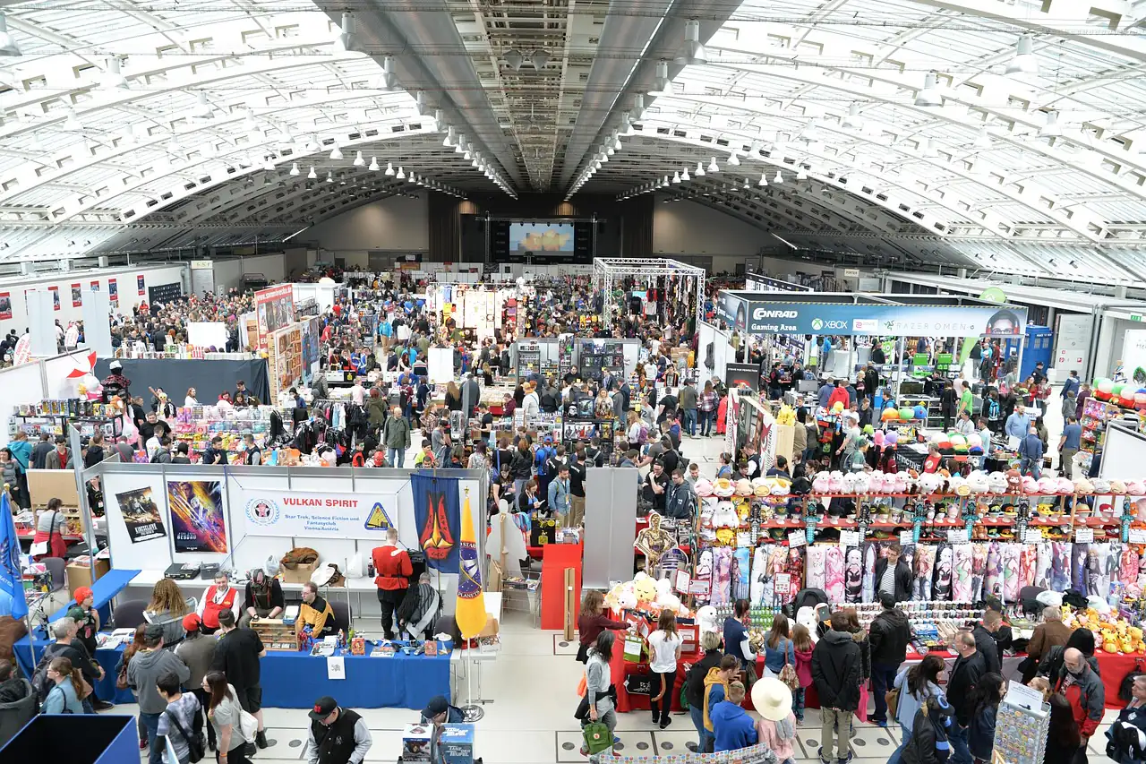 Crowds among stalls in a large exhibition hall