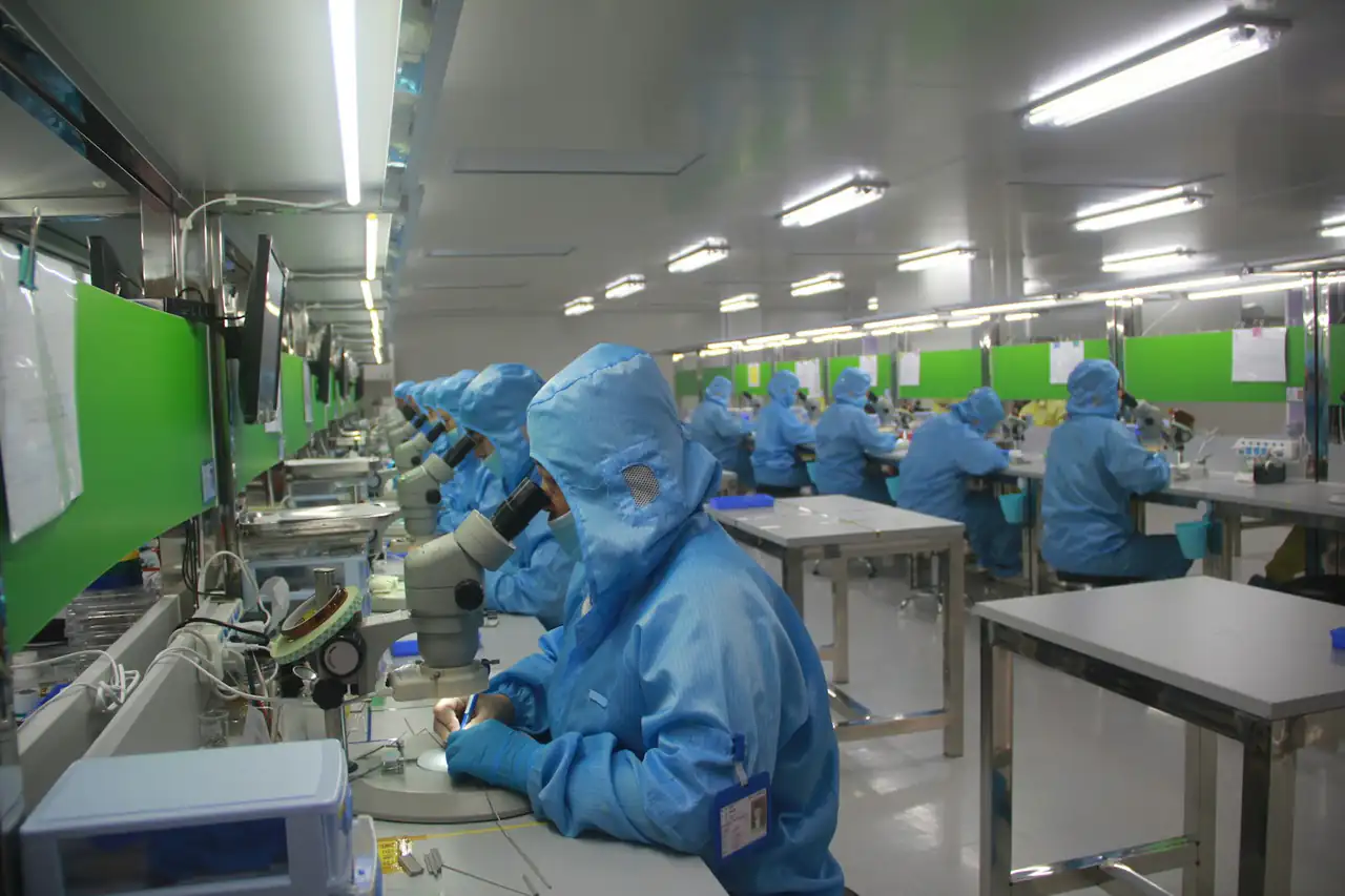 Workers in protective suits on a production floor