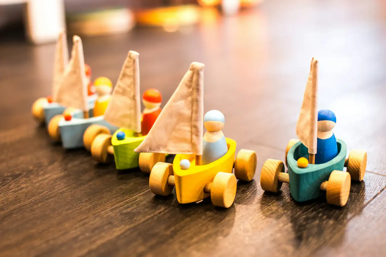 Small wooden toy boats lined up on a table