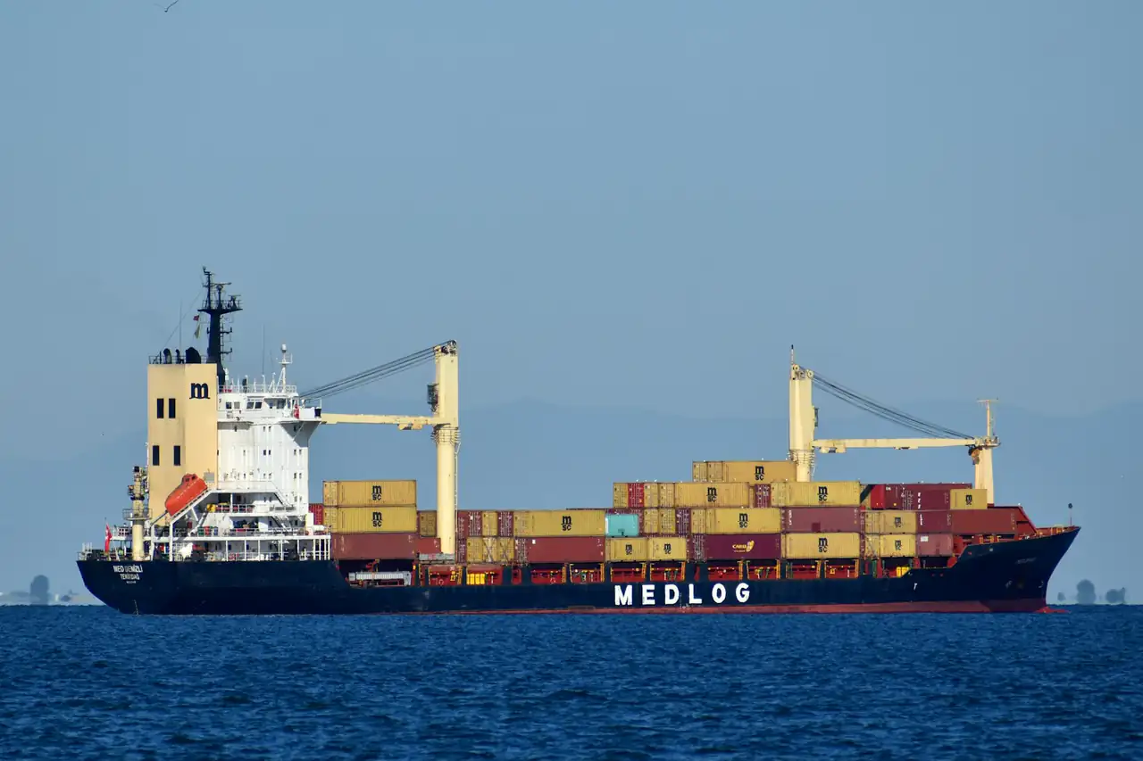 A container ship stacked with boxes on open water