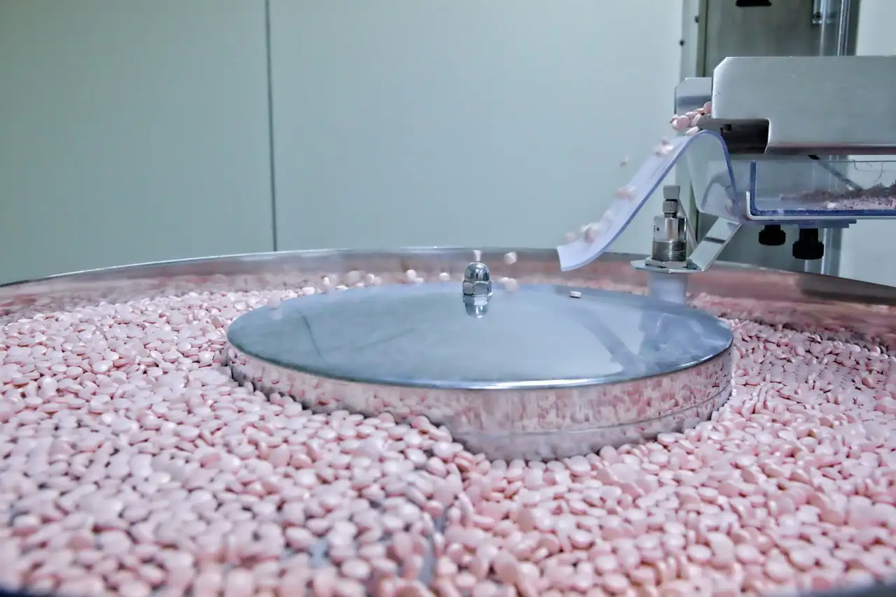 Tablets tumbling in a coating drum at a pharmaceutical plant