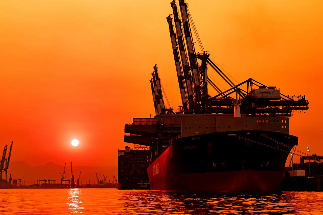 Port cranes against an orange sunset