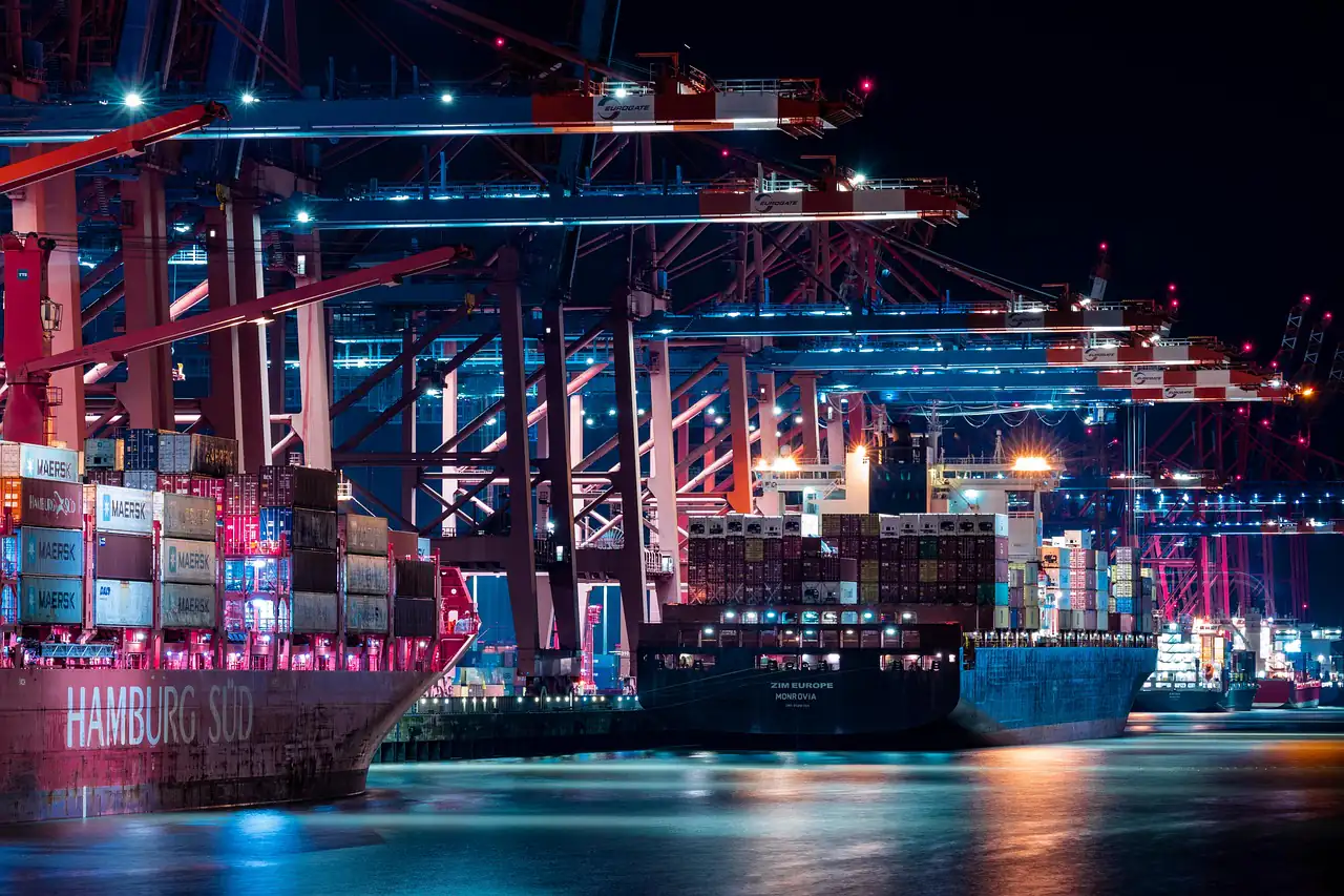 A container ship at a lit terminal at night