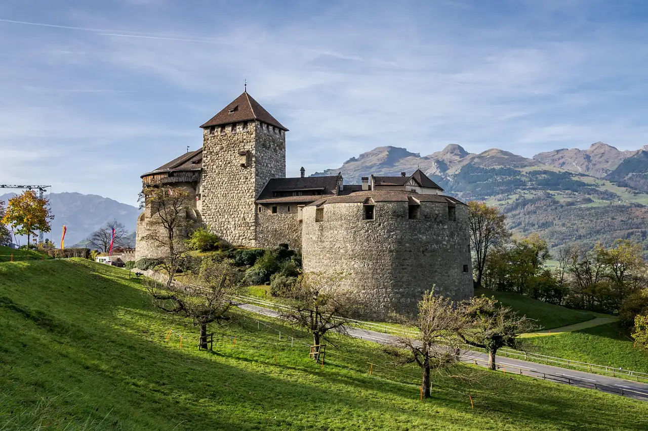 A hilltop castle above green meadows and mountains
