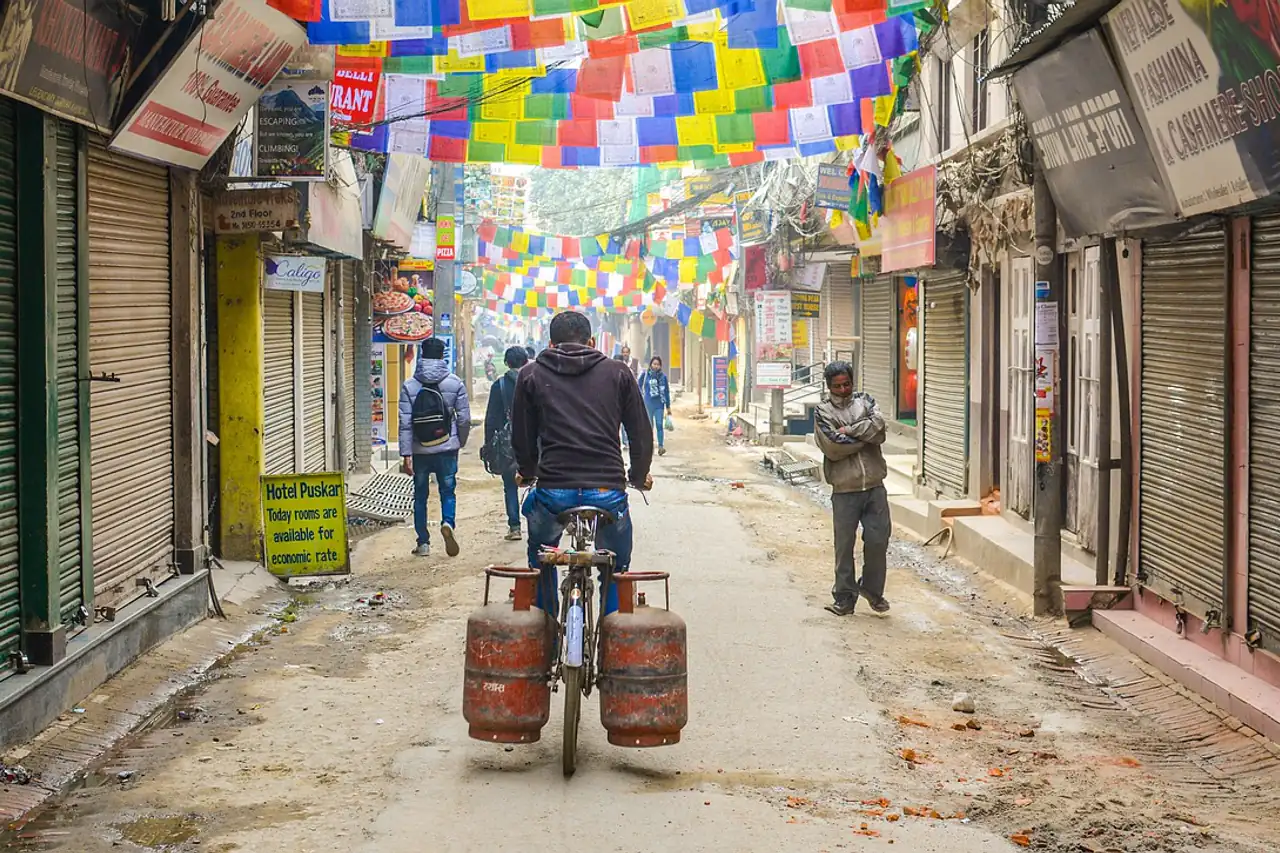 A narrow shop street hung with prayer flags