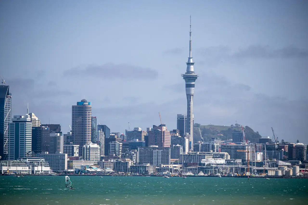 A city skyline with a tall tower across the harbour