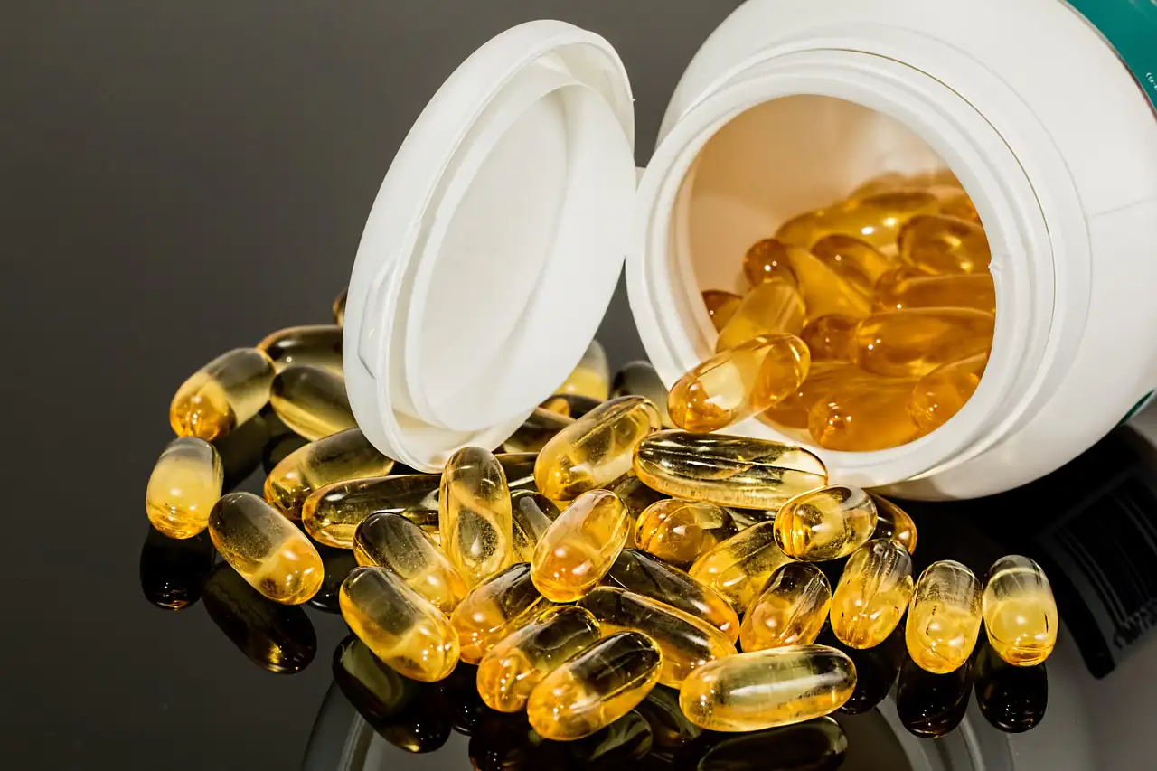 Gel capsules spilling from an open bottle