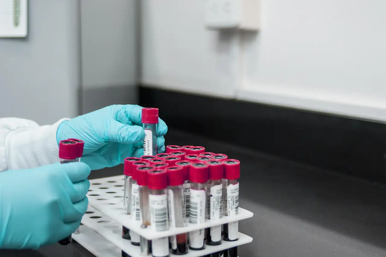 Gloved hands handling sample tubes in a lab