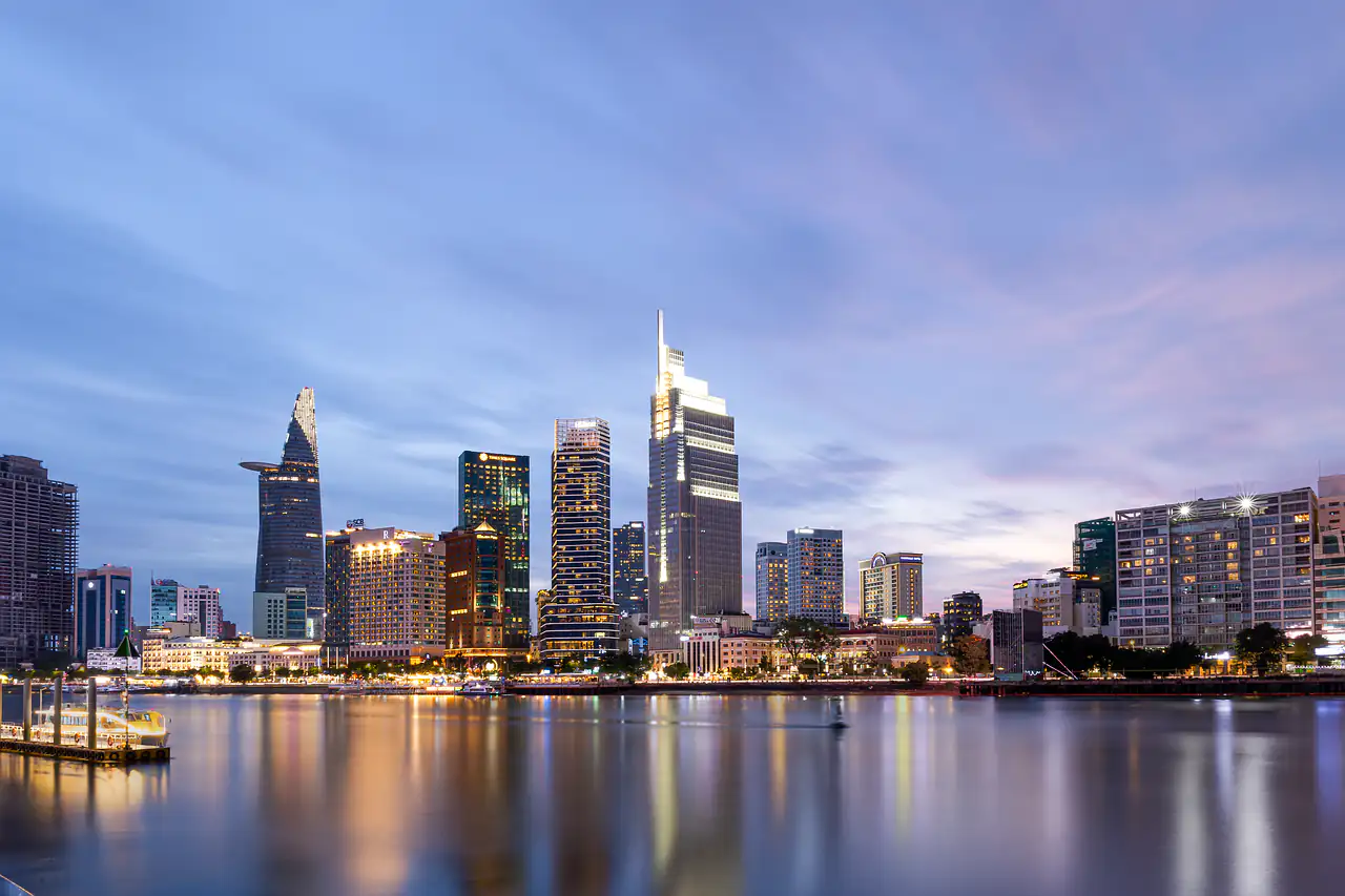 A city skyline across a river at dusk