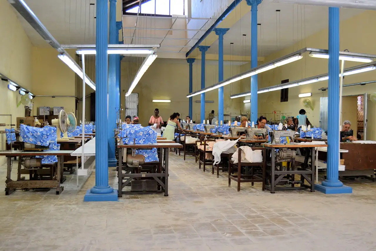 A large garment factory hall with rows of sewing stations