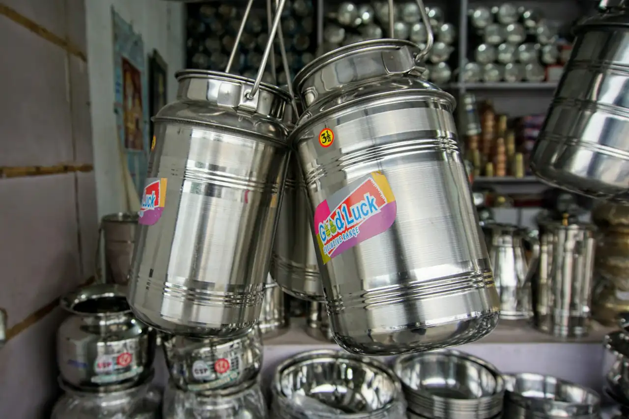 Steel kitchen pots and containers hanging in a shop